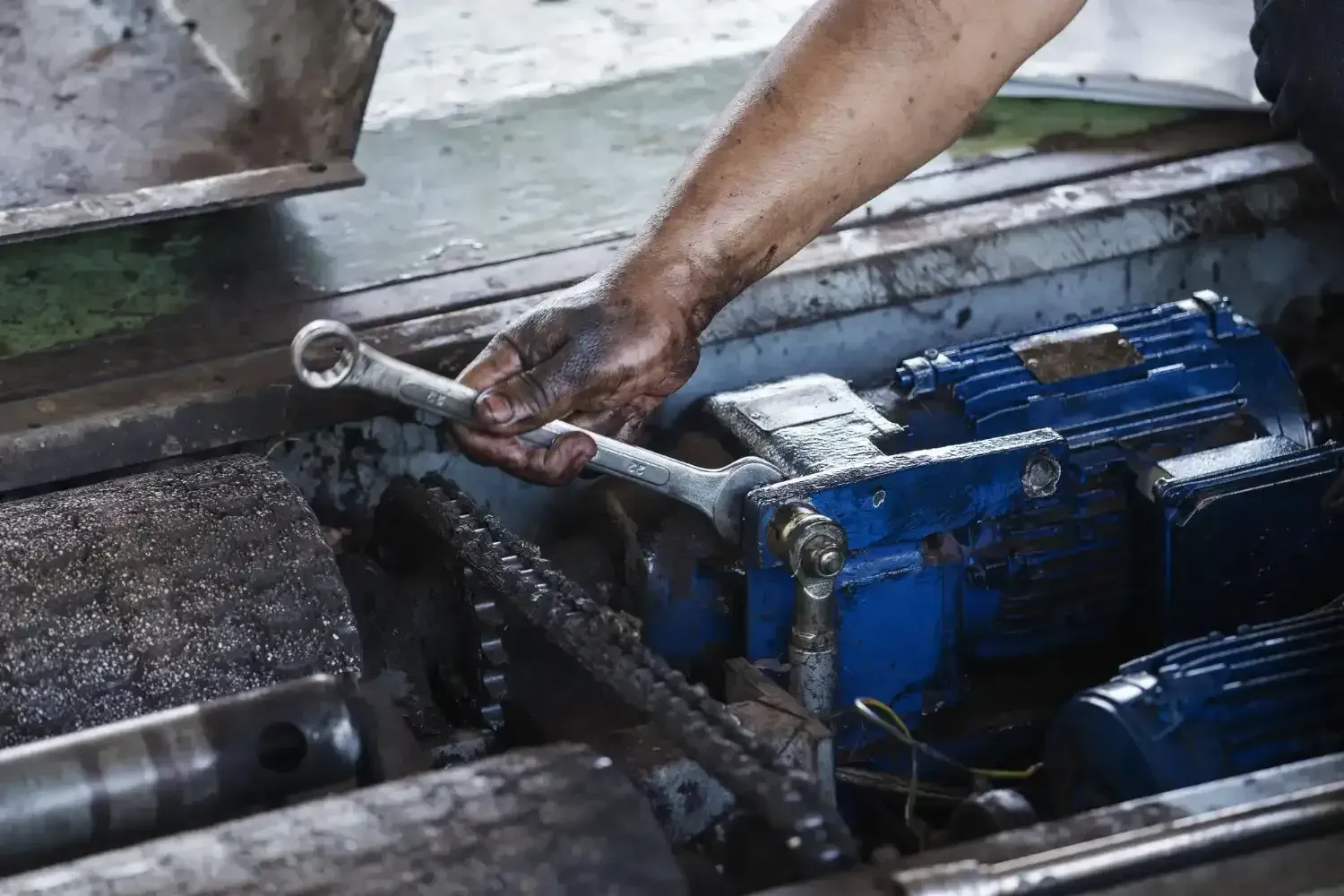 Technician repairing a pump with a wrench